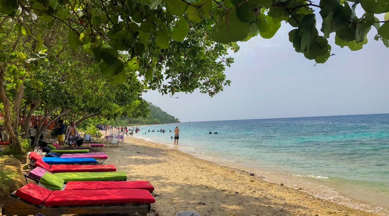 Lounge chairs beneath trees at Taino Beach, Grand-Goâve, Haiti