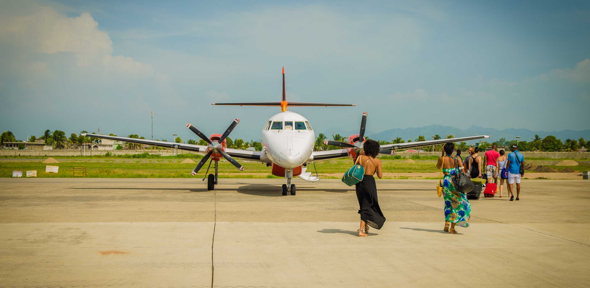 Women in dresses about to board a plane at