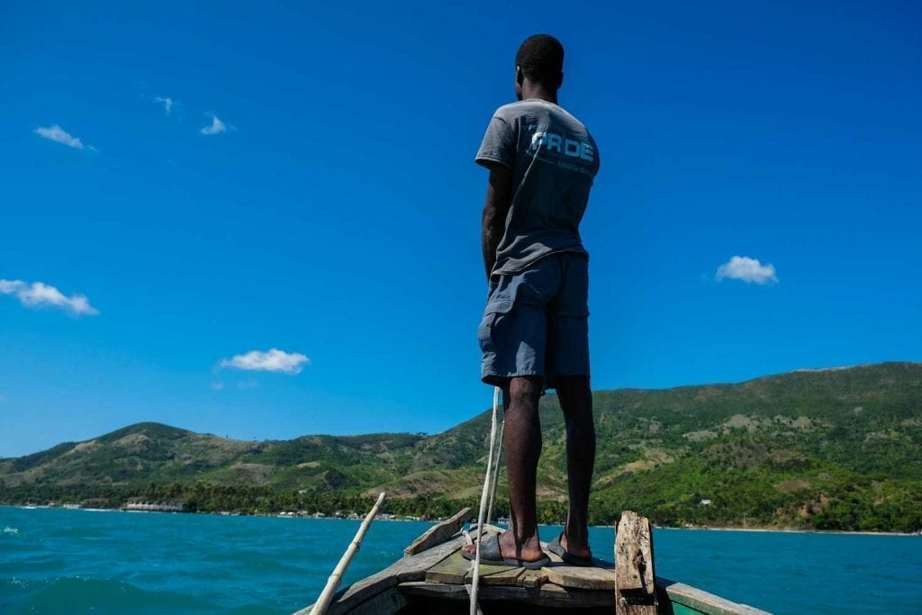 Pilot stands on the bow of a boat to