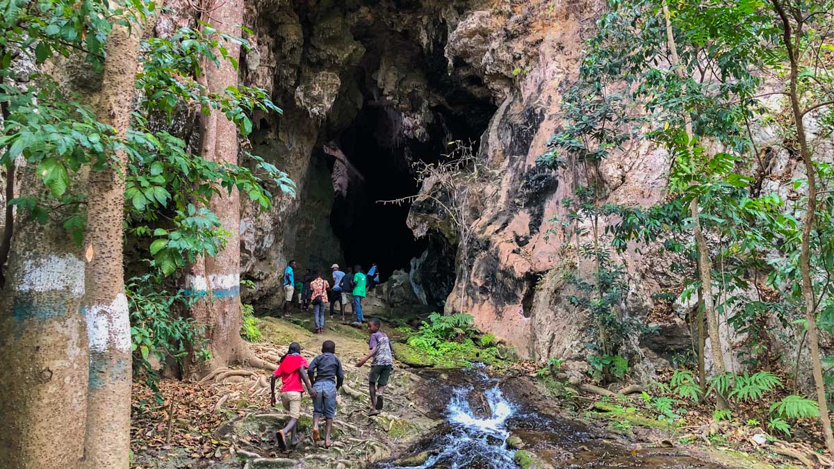 Group of people walking up to the entrance of the caves at Bassin Zim, Haiti