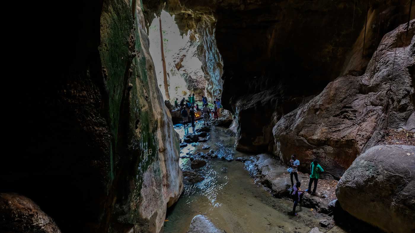 Group of people walking through the caves at Bassin Zim, Haiti