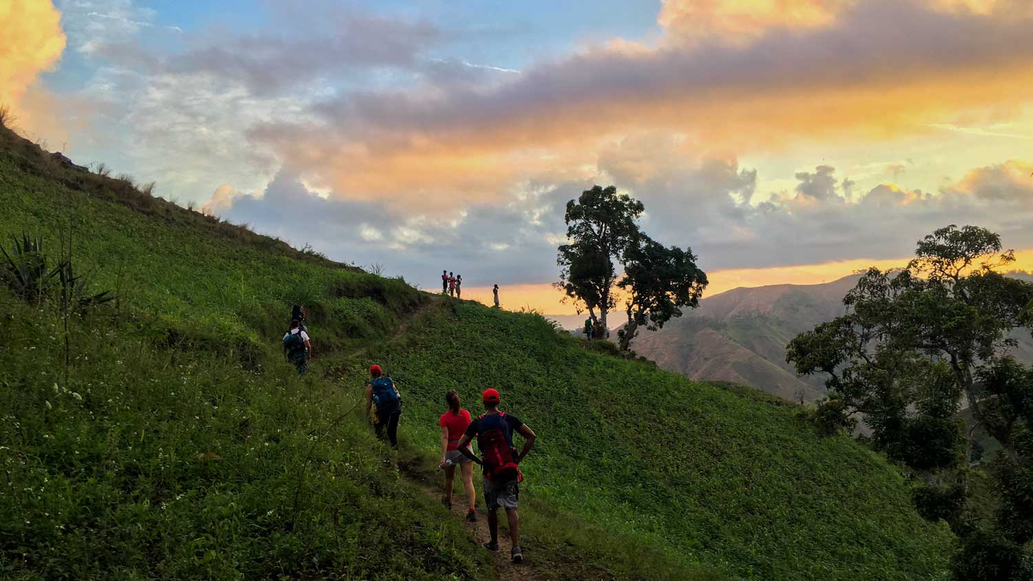 People hiking across a hill in Grandou, Haiti