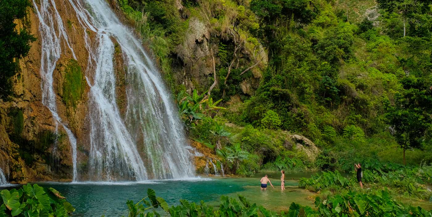 Three travellers wading in the Kaskad Pichon waterfalls, Haiti