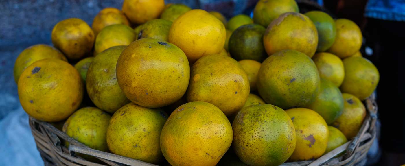 Basket of fresh green oranges at a market