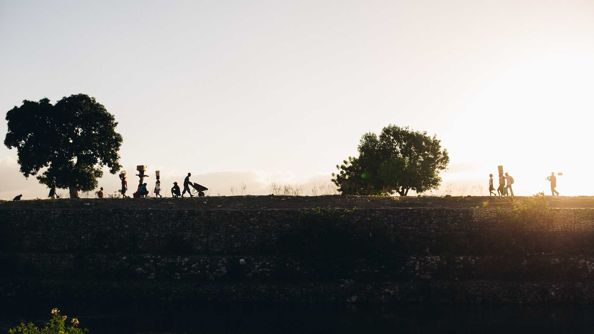 People walking across the horizon at sunset, Haiti