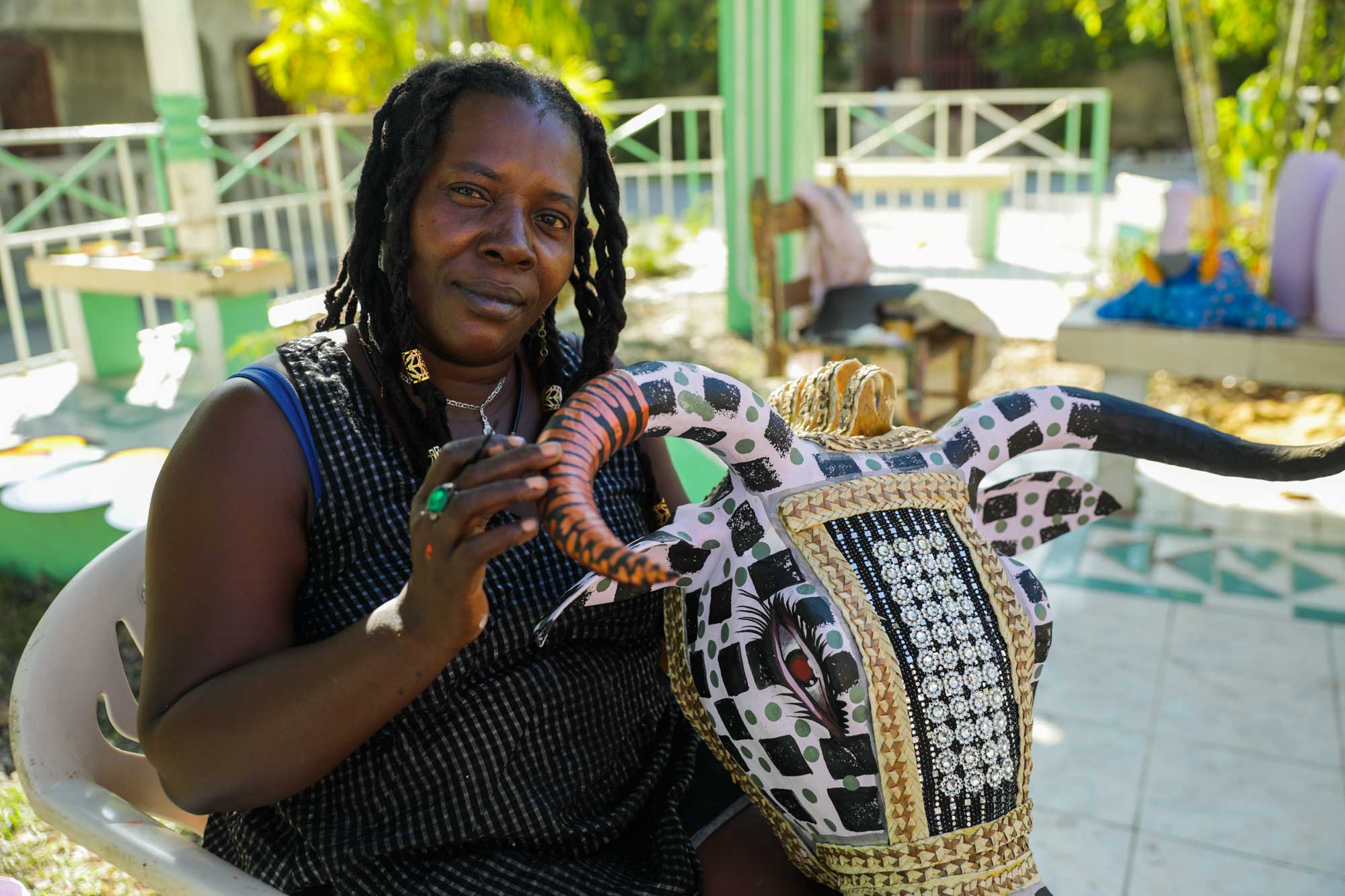 Paper mâché artist Charlotte shows off an intricate cow mask in Jacmel, Haiti