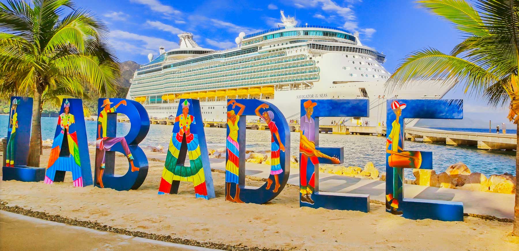 Artwork spelling out the name Labadee stands on Labadee beach, Haiti, with cruise ship docked in background