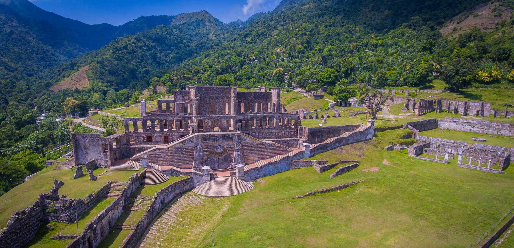 Aerial view of Sans-Souci Palace, Haiti, with tree-covered mountains in the background