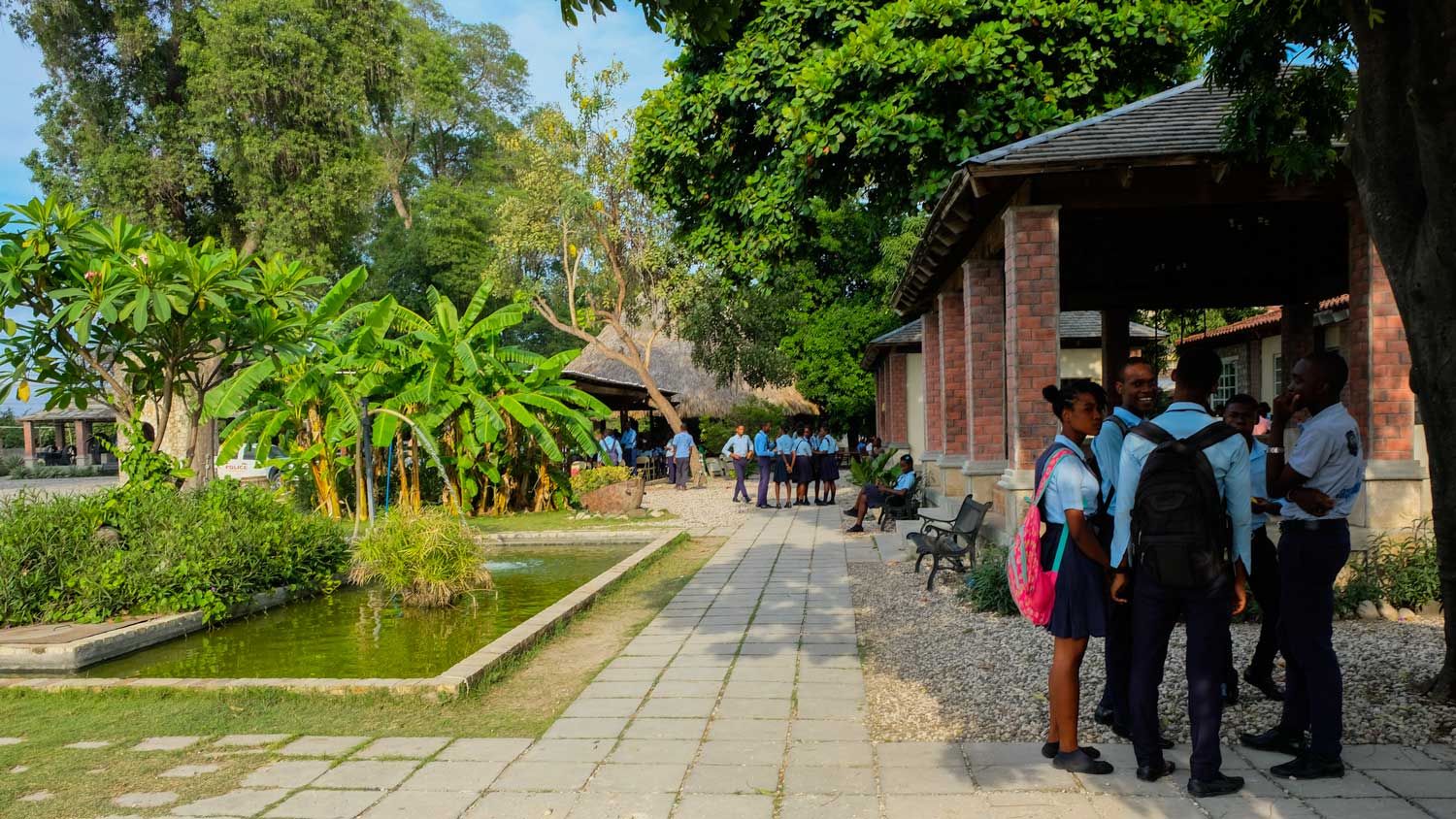 Schoolchildren stand in conversation on a visit to Parc Historique de la Canne à Sucre, Haiti