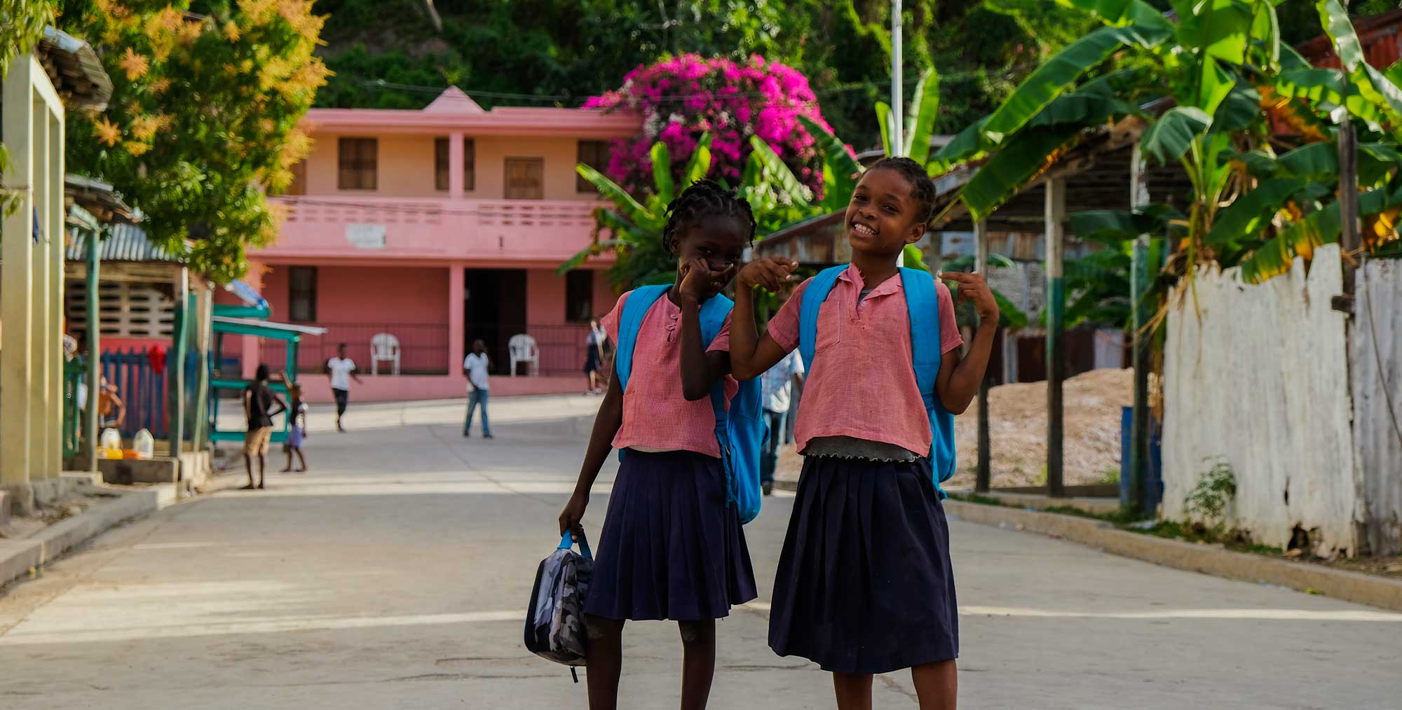 two haitian school girls in uniforms smiling