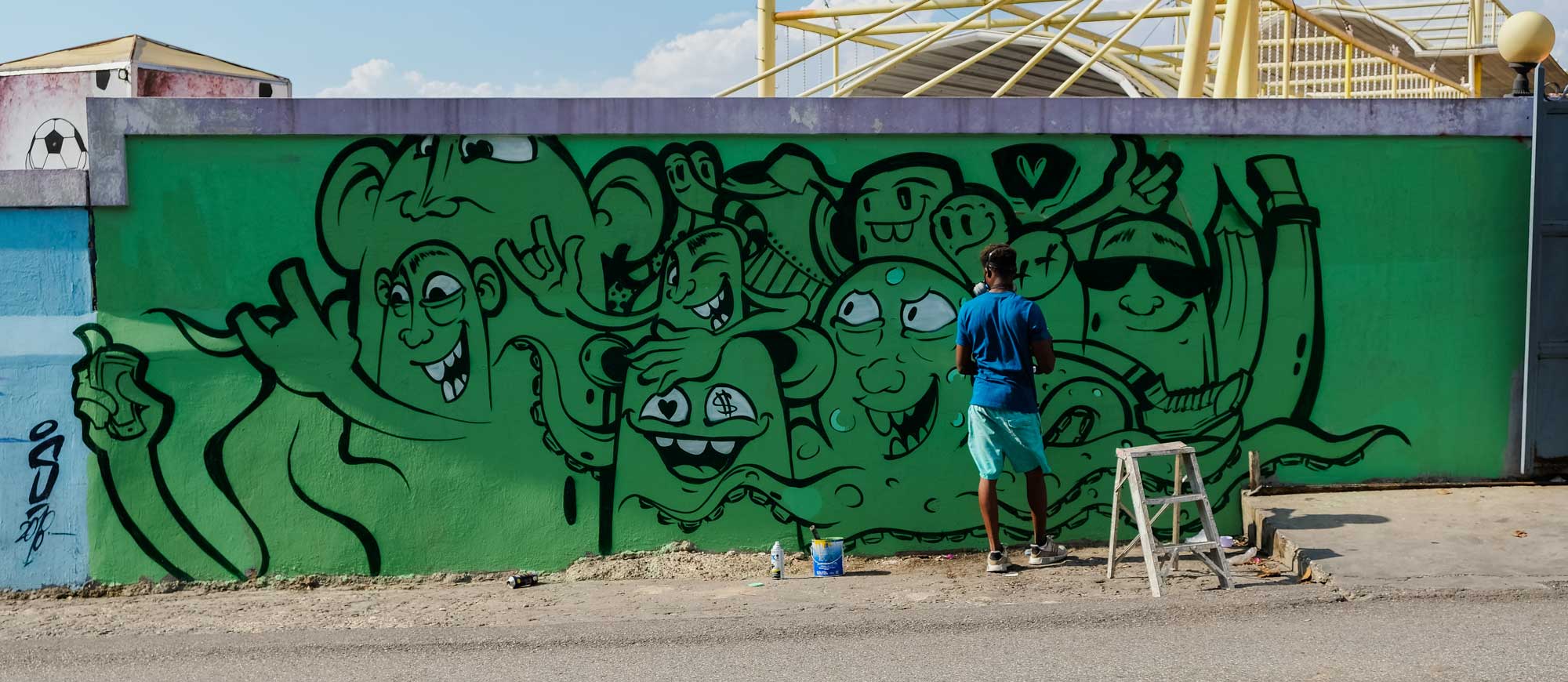 street artist painting a graffiti mural 