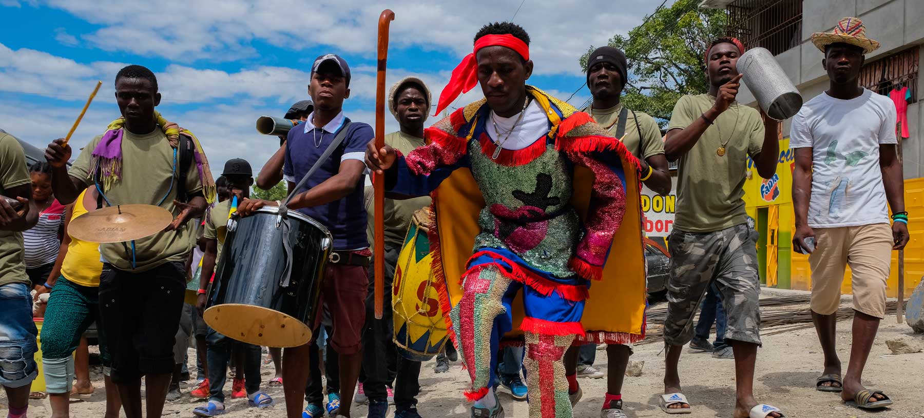 group of haitian walking while playing on trumpets during rara festivities