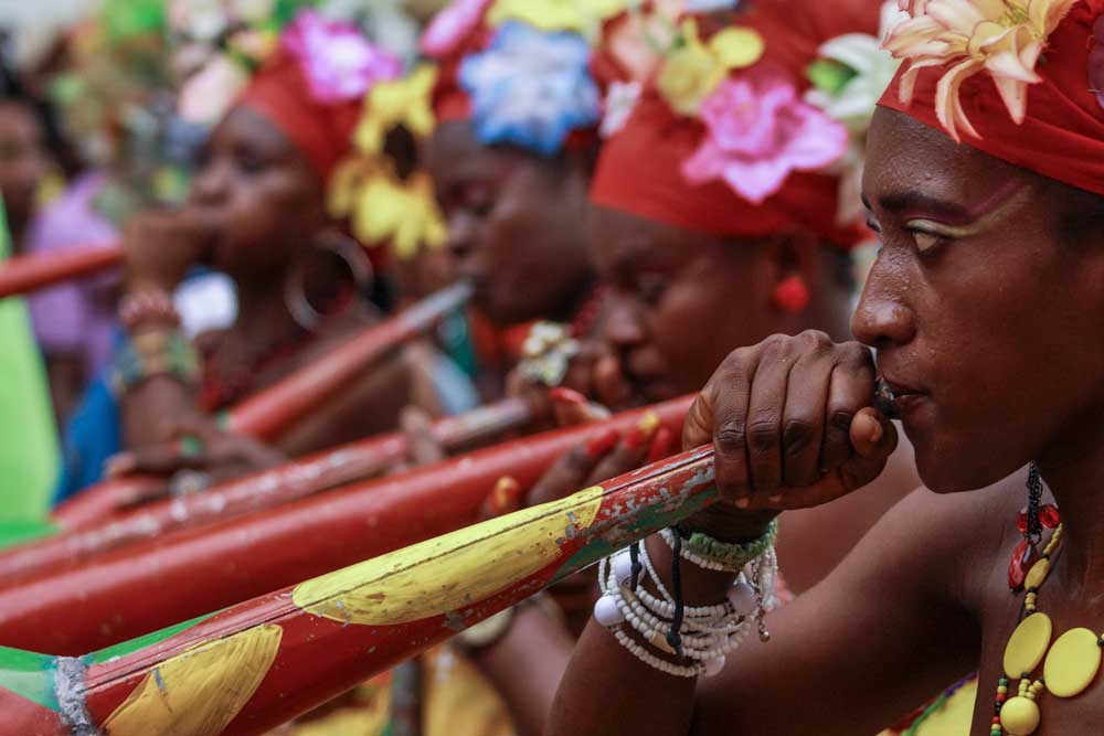 haitian women in carnival decorations with trumpets