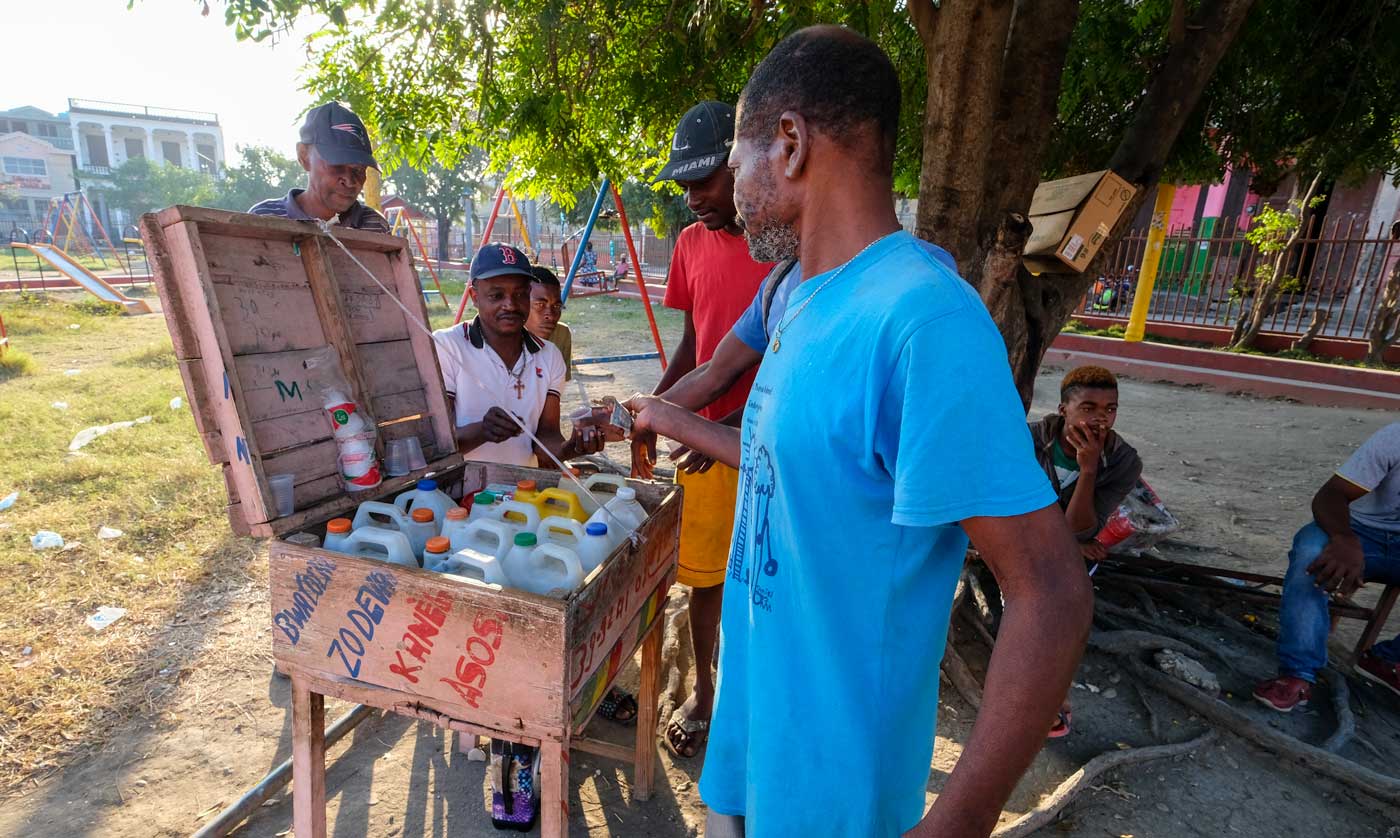 group of haitian men among a alcohol vendor