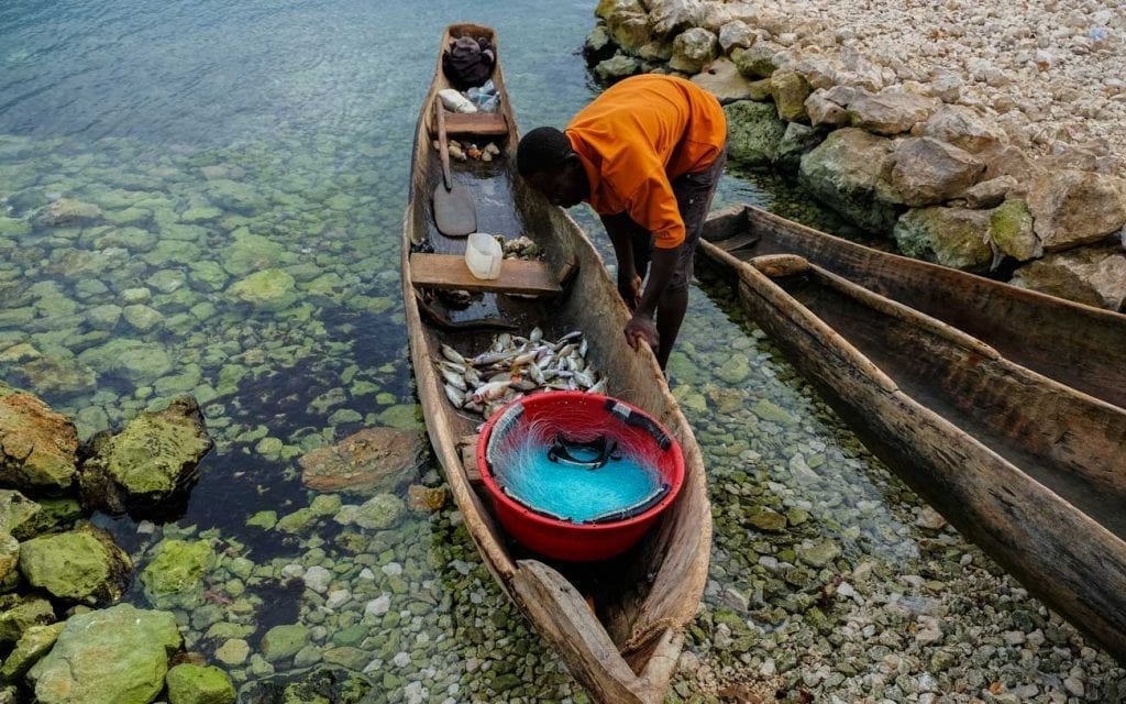 haitian fisherman with small wooden cannoo