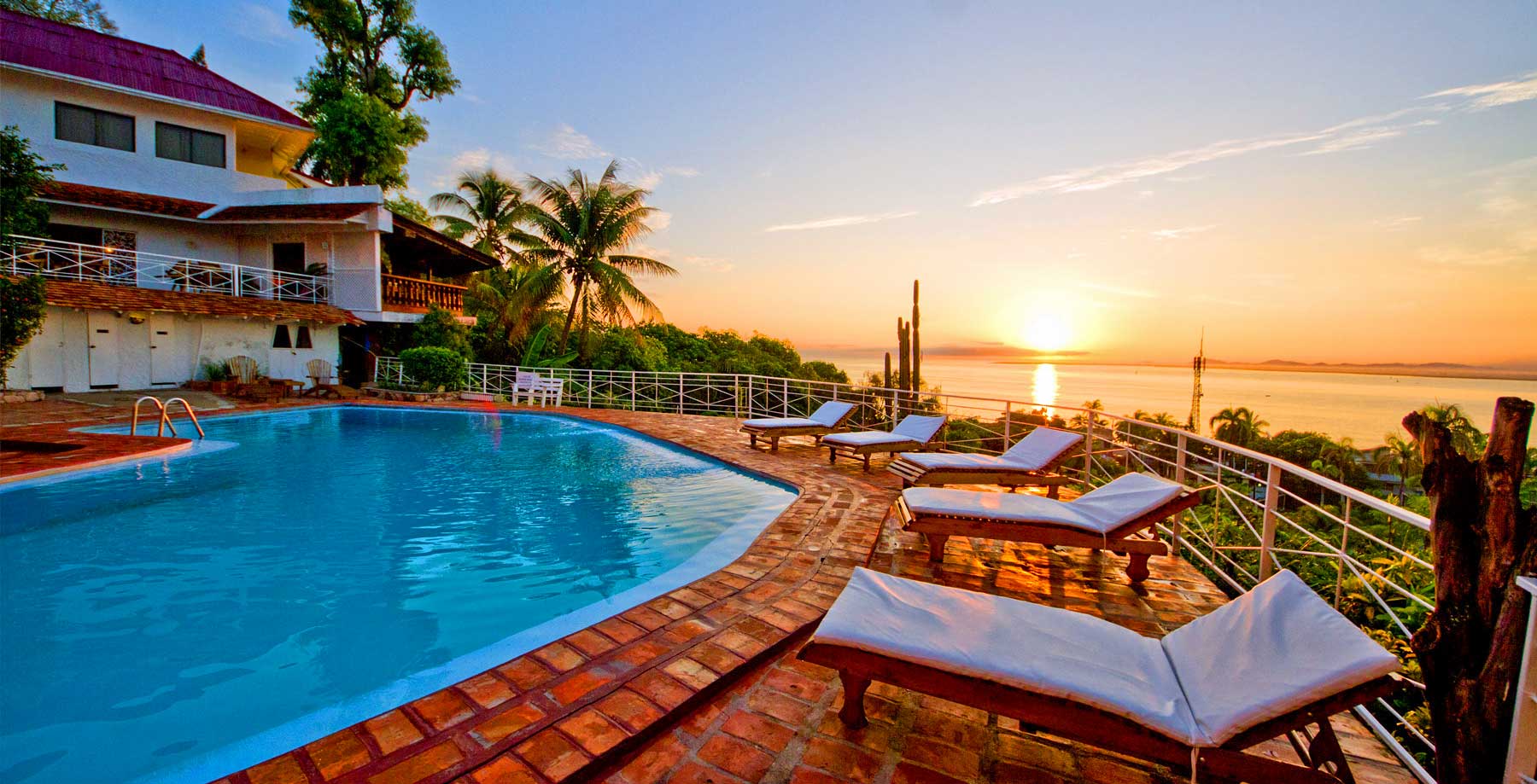 hotel pool with lounge chairs and ocean view