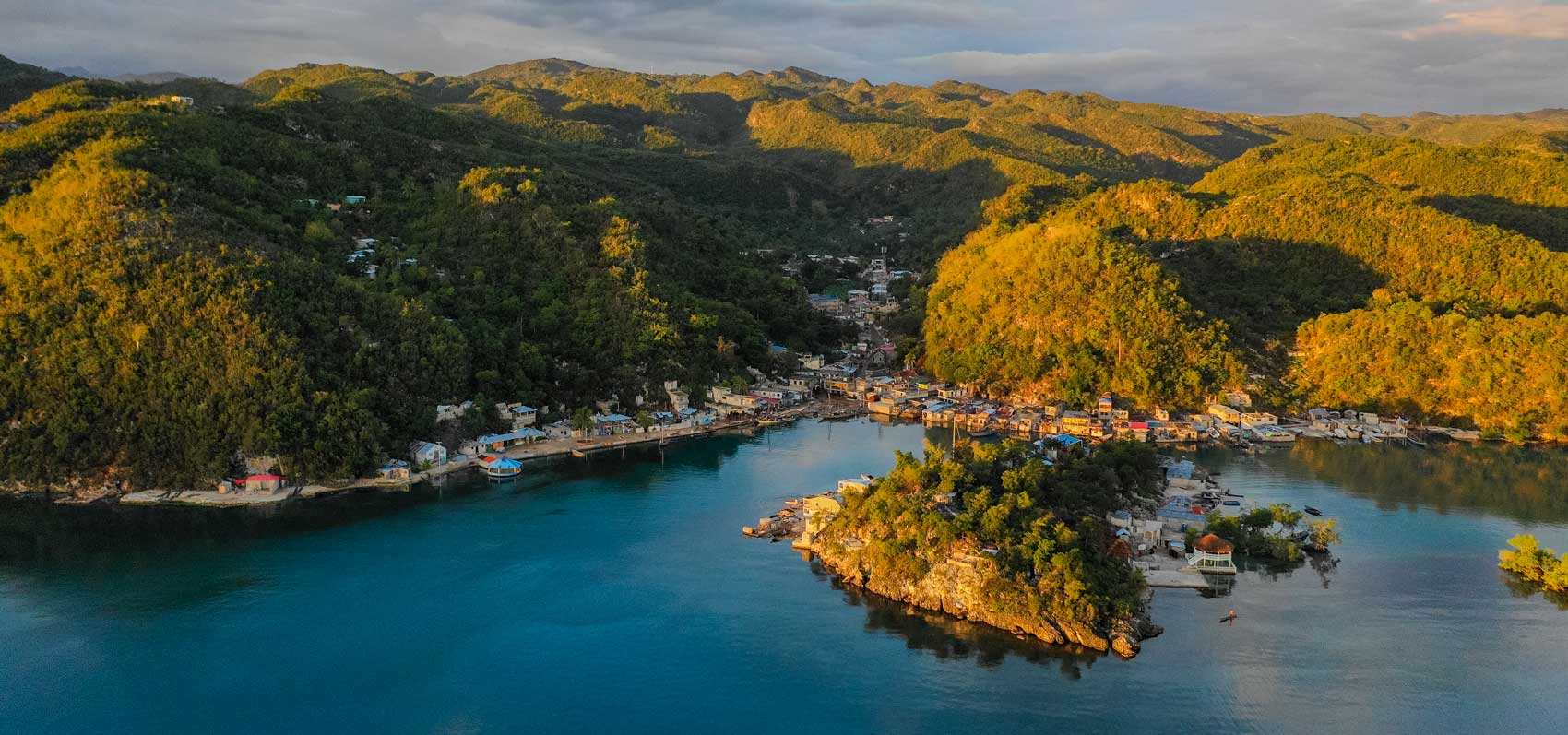 sunrise over the mountains surrounding a small haitian fishing village