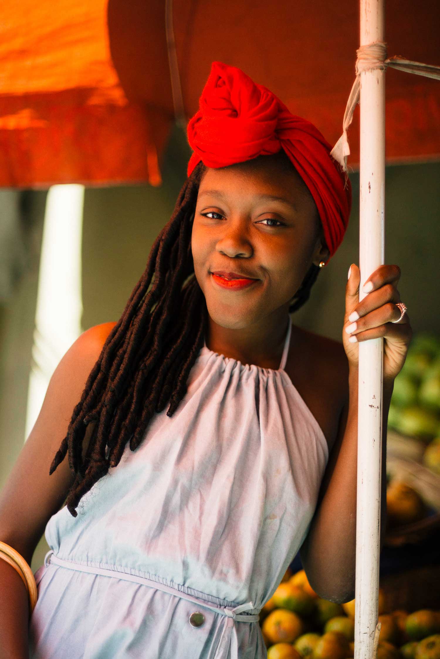 portrait photo of young stylish haitian girl with long dreadlocks and red head scarf