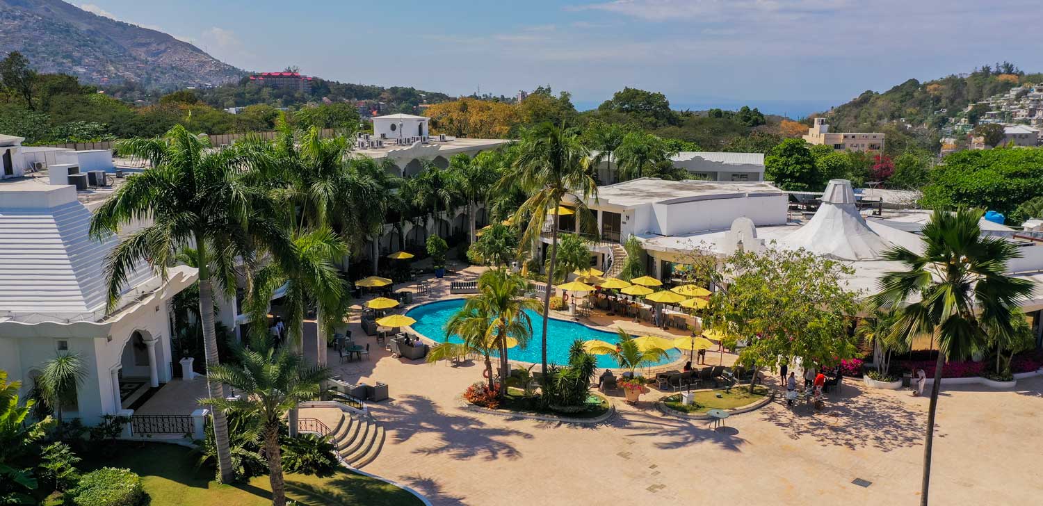 haitian hotel with pool area and palm trees