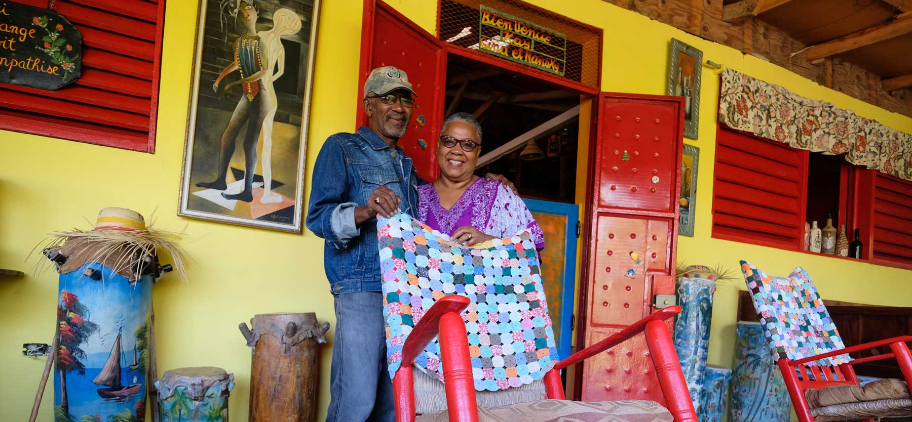 haitian man and woman posing behind a rocking chair