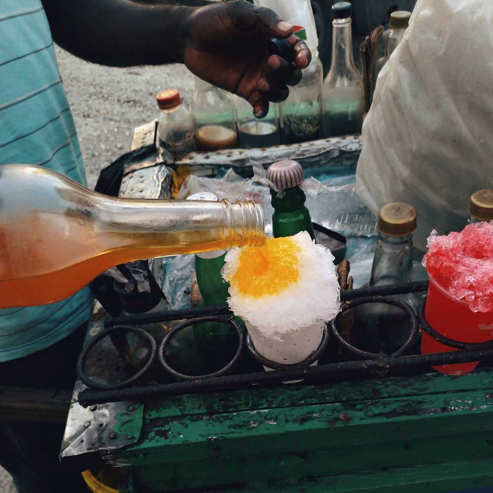 vendor pouring syrup on shaved 