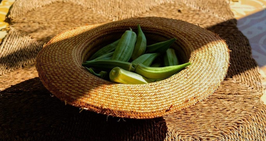 a straw hat filled with okra