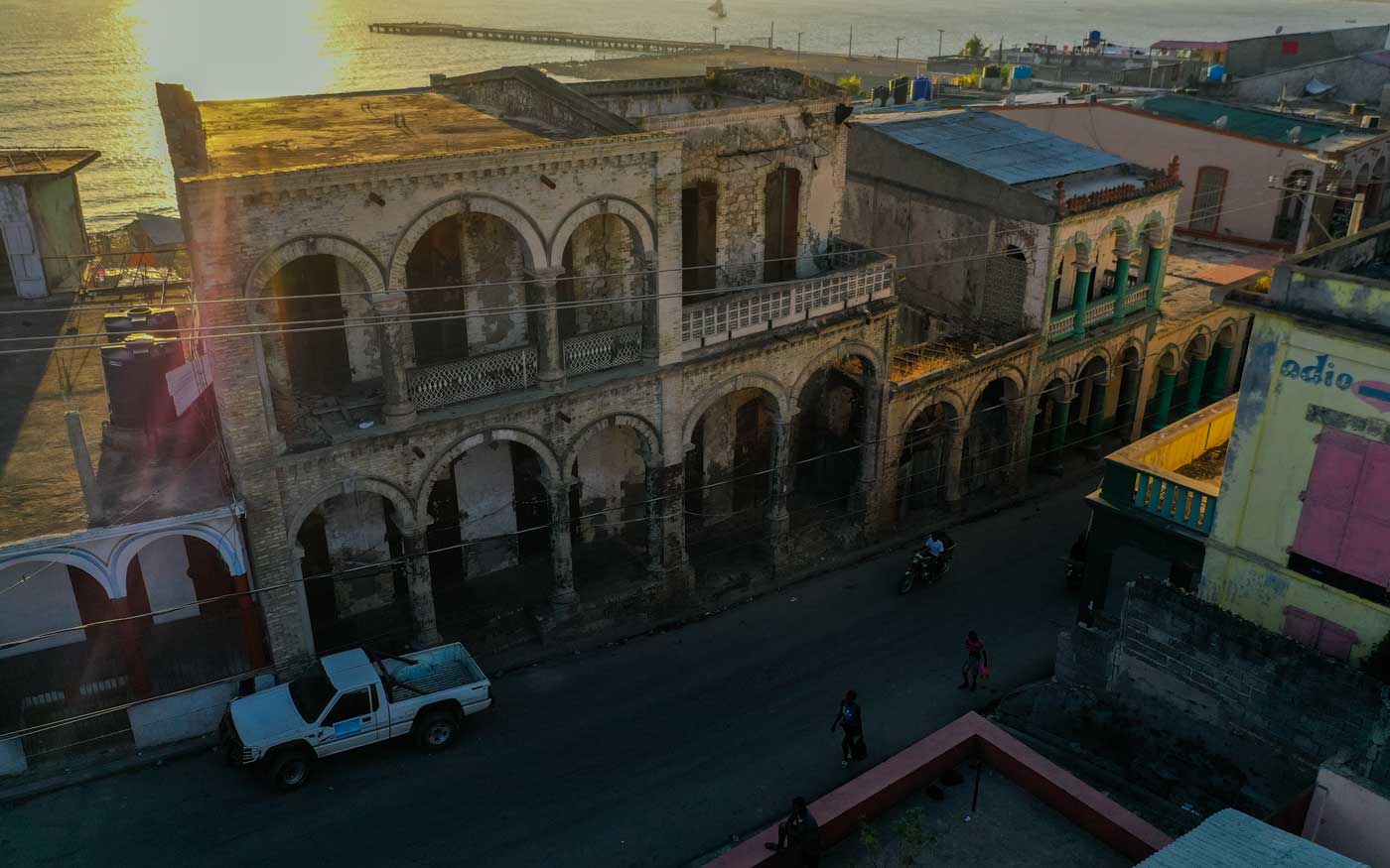 old colonial houses lined on street with ocean in background