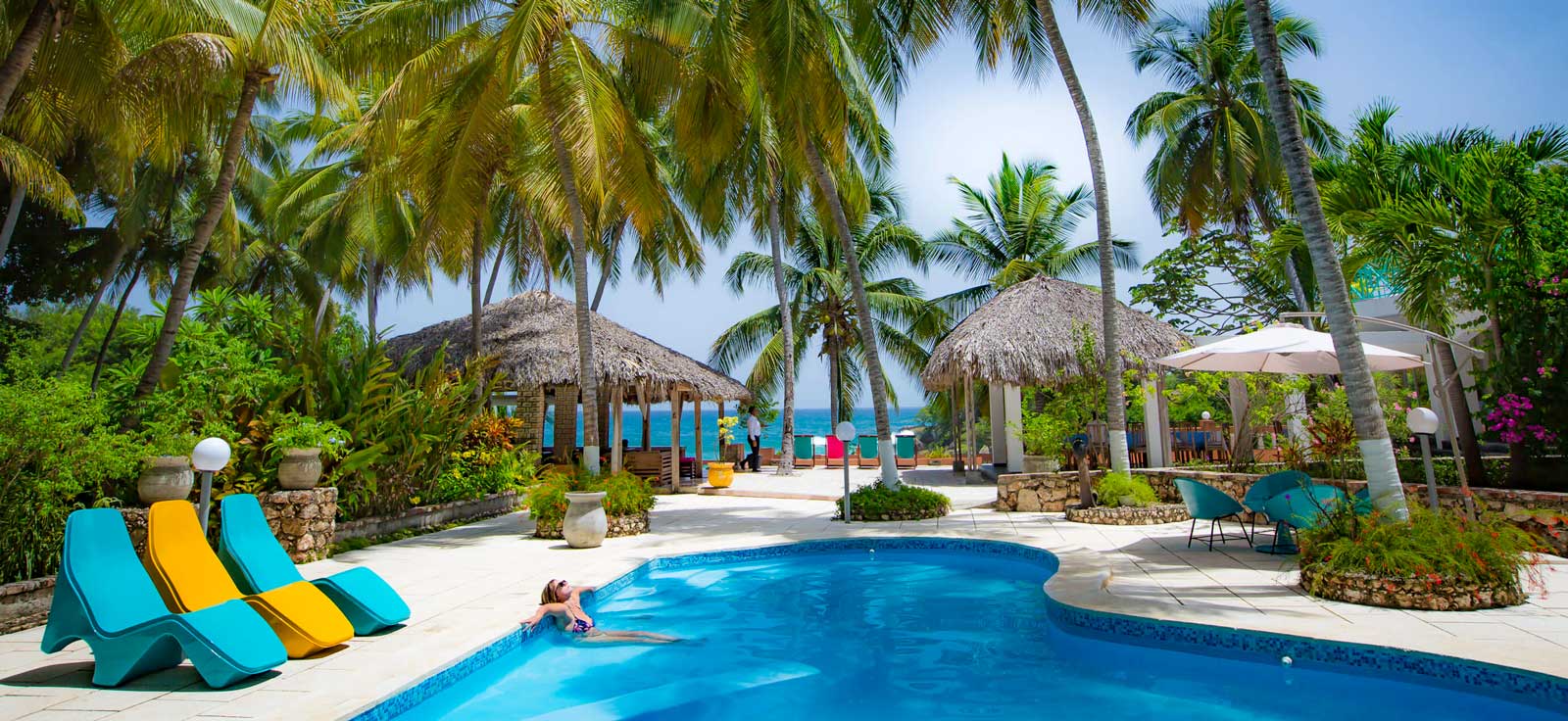 hotel pool with palm trees and sea view