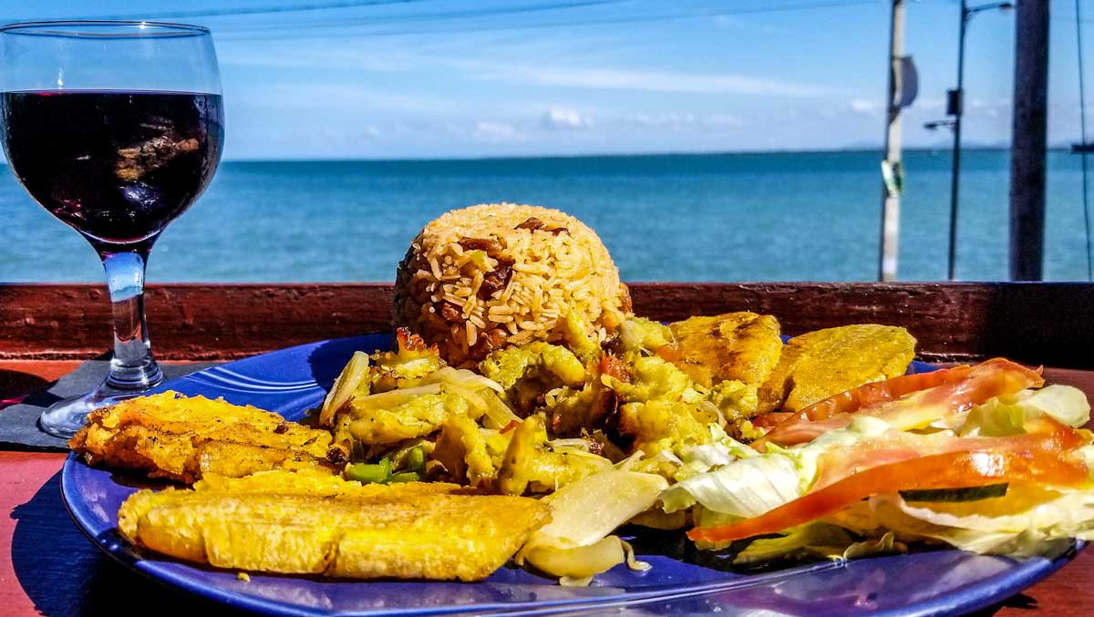 plate with grilled conch, fried plantains, rice and salat