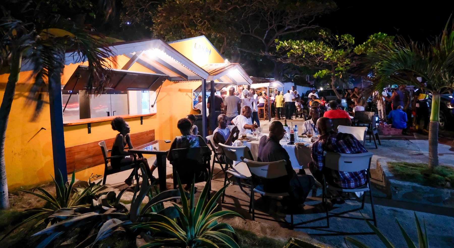 people seated at tables dining outside a restaurant