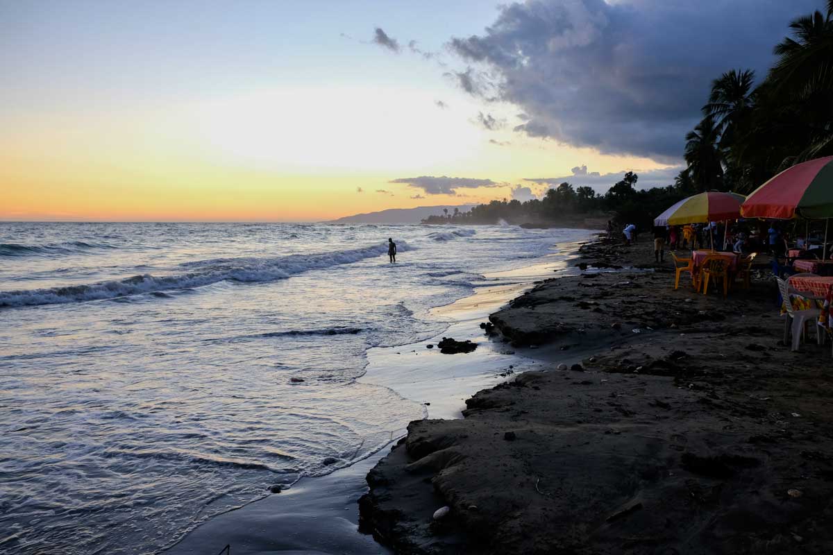 sunset over beach with tables and 