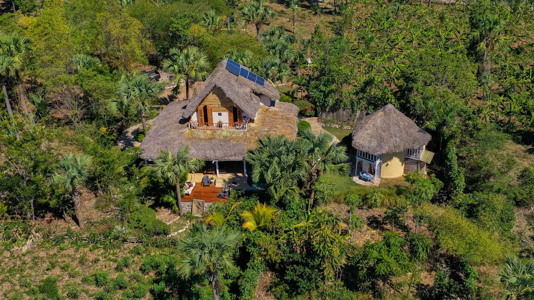 small hotel with thatch roof in tropical forest