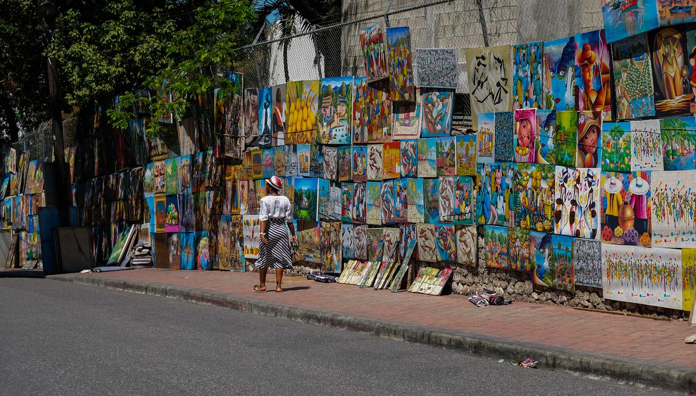 rue avec des femmes marchant et des peintures exposées