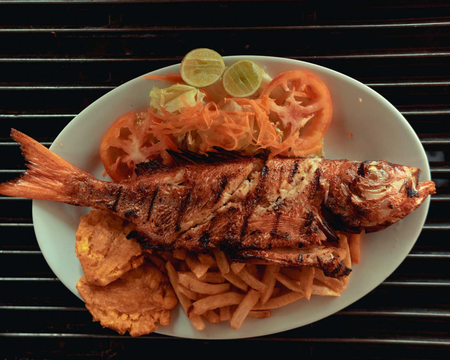 plate with grilled fish, fried plaintain