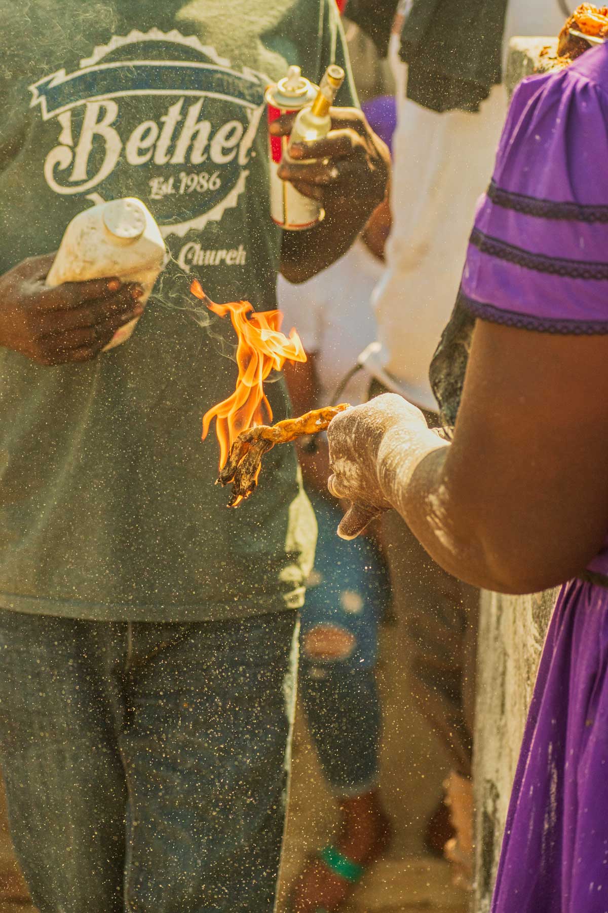 haitian vodou practitioners lighting a candle during fet gede