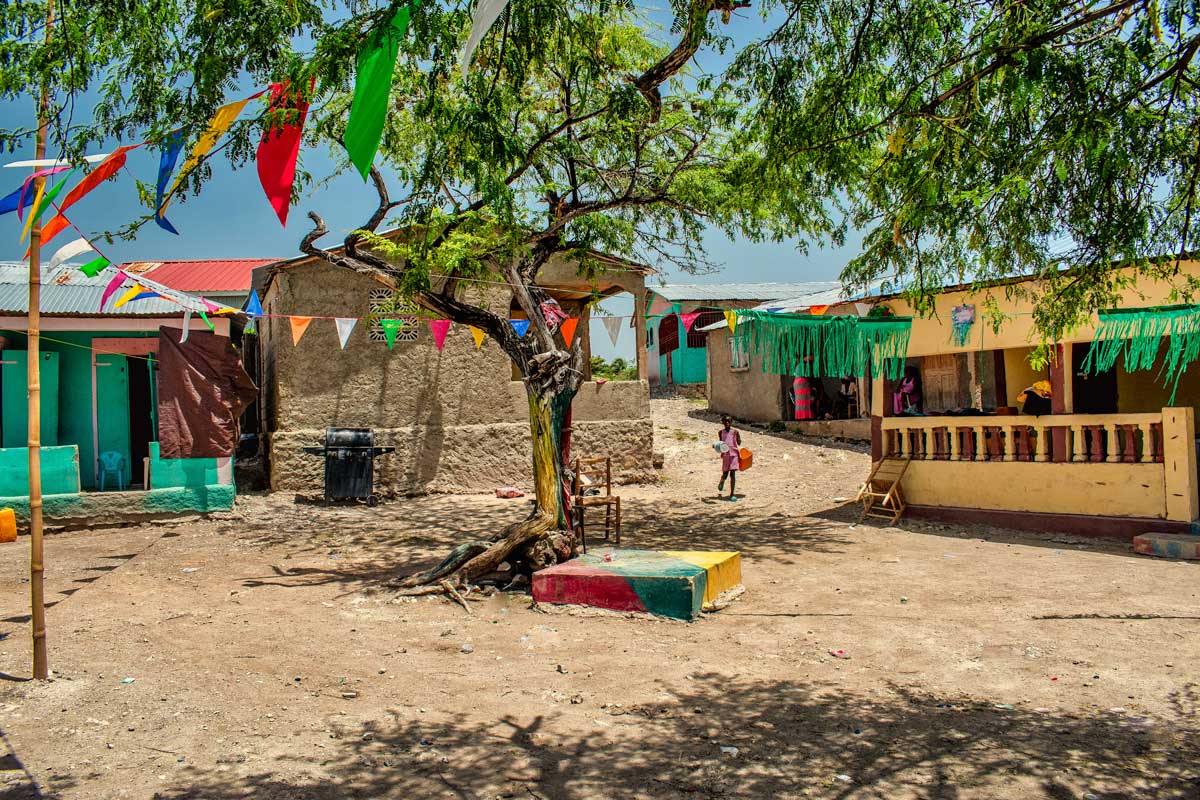 courtyard area in a vodou lakou with trees and girl