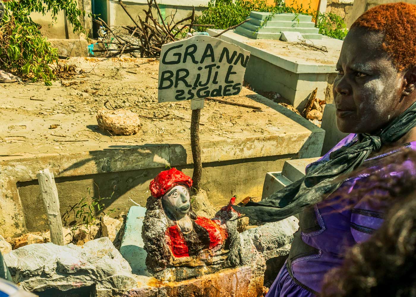 pratiquante vaudou haïtienne au cimetière portant une robe noire et violette