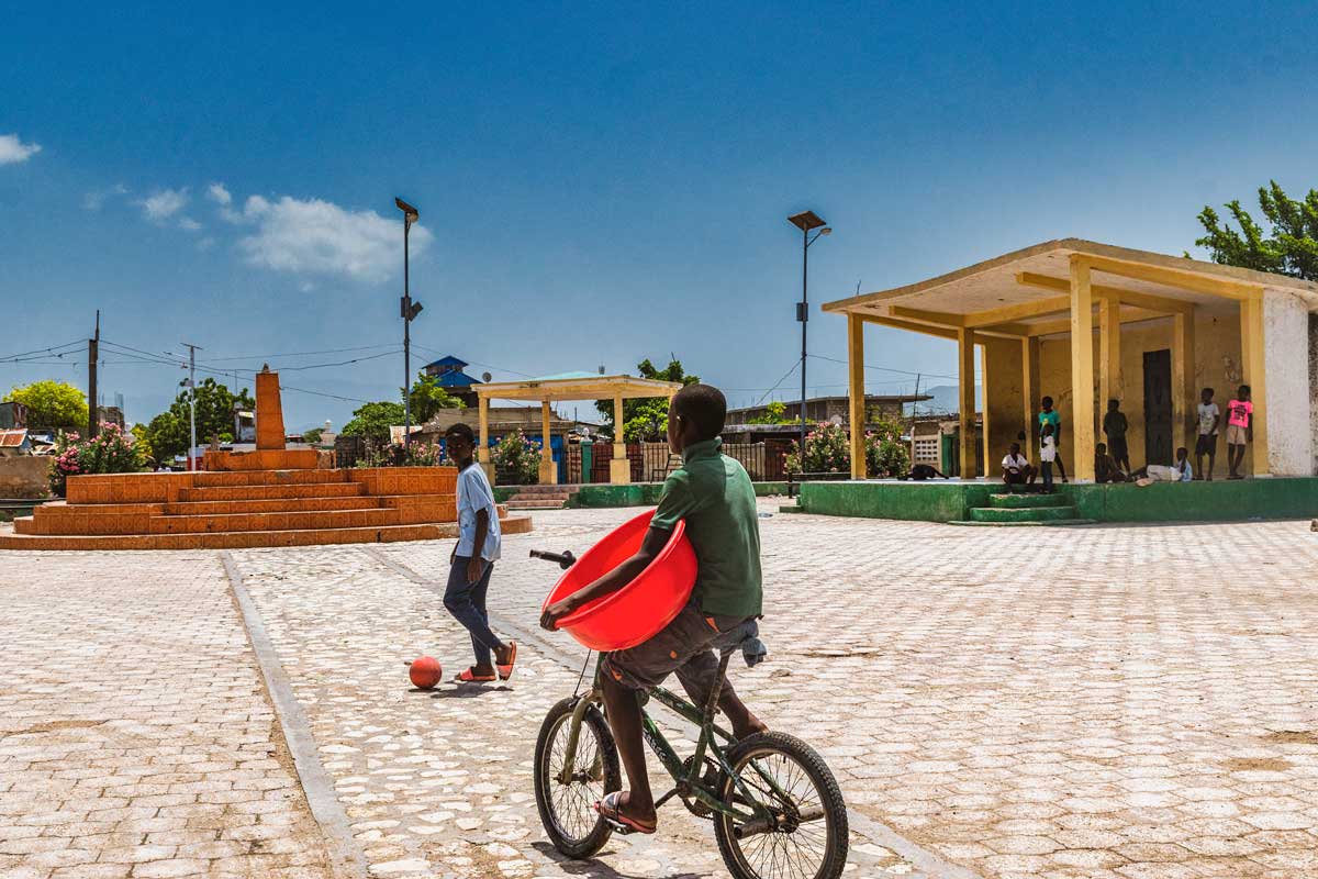 public city square with boy on bmx bike and boy with football