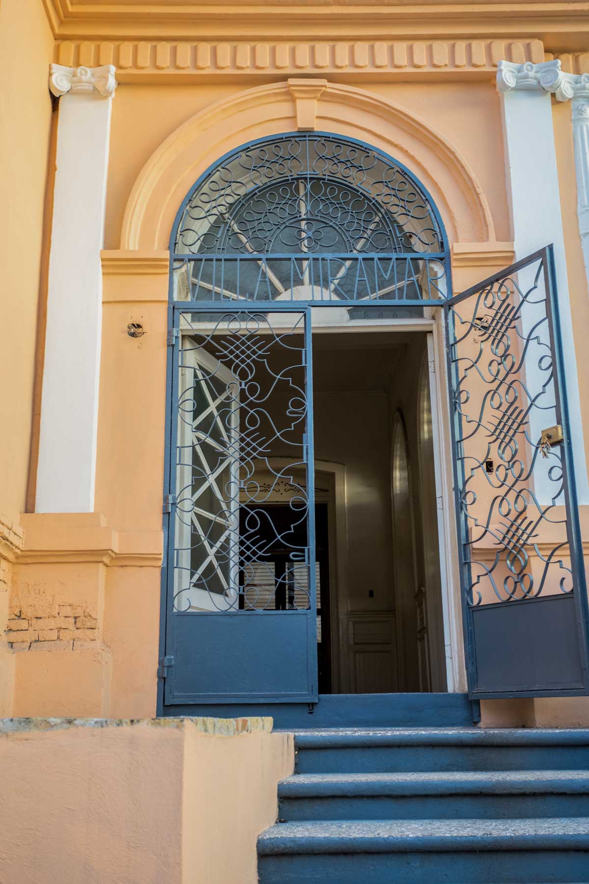 stairs to large door entrance to house with decorative metal details