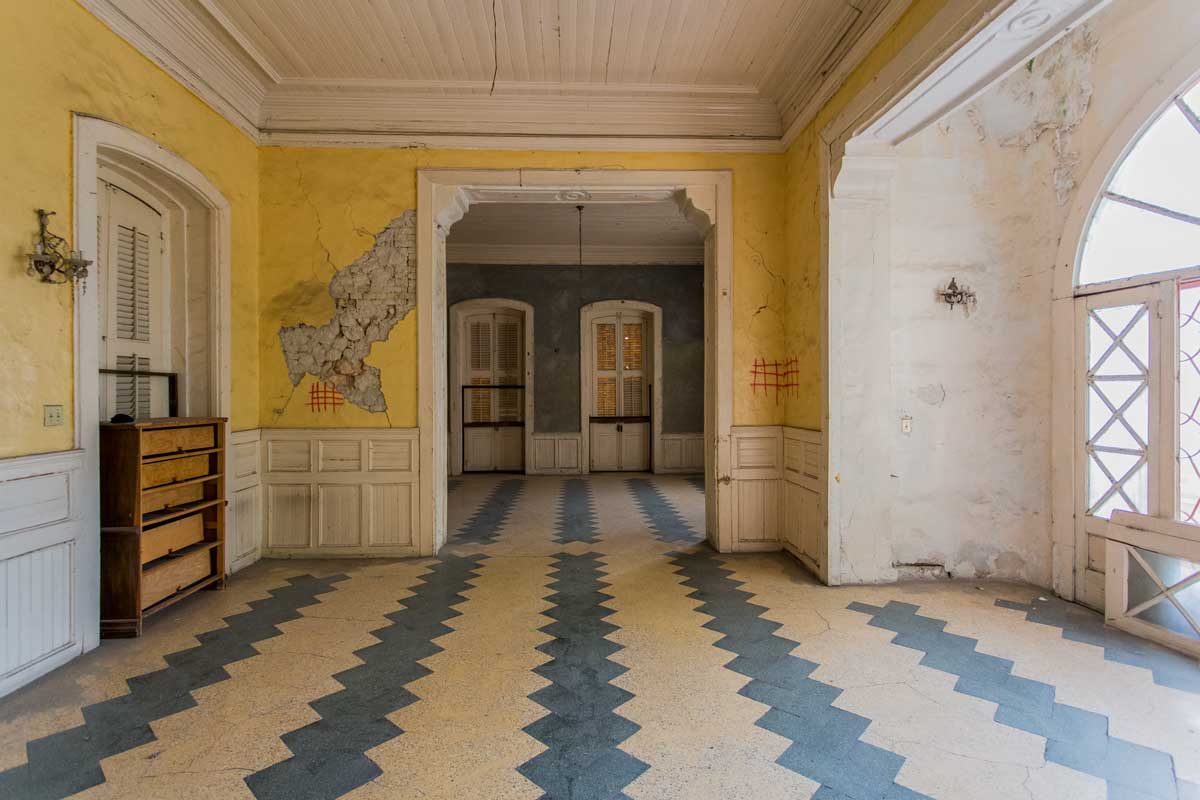 interior of old gothic gingerbread mansion with tile floor and structual damage